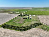 Expansive aerial view of a farm with silos, outbuildings, and surrounding fields under a clear blue sky at 0 Tbd E 112Th Ave, Bennett, CO 80102