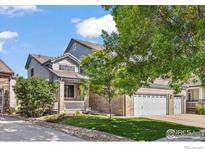 Charming two-story home showcasing a brick facade, well-maintained lawn, and a three-car garage at 11861 Fairplay St, Commerce City, CO 80603