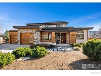 Stunning contemporary home with stone and wood accents, complemented by professional landscaping at 3875 Cloverleaf Dr, Boulder, CO 80304