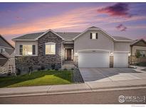 Charming single-Gathering home boasts a three-car garage, stone accents, and a well-manicured front yard at dusk at 4600 Shady Path Ln, Castle Rock, CO 80104