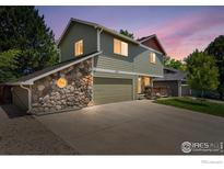 Two-story home featuring stone accents, a two-car garage, and well-maintained landscaping against a colorful sky at 602 S 9Th St, Berthoud, CO 80513