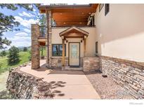 Inviting home entrance with stone accents, complemented by a pathway and partial mountain views at 8323 Thunderhead Dr, Boulder, CO 80302