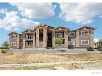 Apartment building with a combination of stone and brown siding, plus an open courtyard and a low maintenance yard at 875 E 78Th Ave # 68, Denver, CO 80229