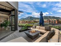 Outdoor rooftop deck features a firepit, comfortable seating, and mountain views at 1360 Walnut St # 401, Boulder, CO 80302