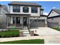 Charming two-story home with a covered front porch, complemented by a well-manicured lawn at 1571 Poplar Dr, Erie, CO 80516
