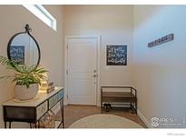 Welcoming entryway with tiled floors, decorative mirror and convenient bench seating with shoe rack at 16527 Fairbanks N Rd, Platteville, CO 80651