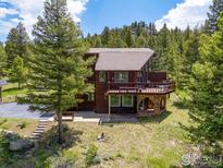 Charming mountain home with a large front tree, wraparound deck, and stone foundation at 173 Silver Cloud Ln, Boulder, CO 80302