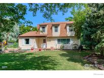 Charming two-story home with a well-maintained lawn and mature trees at 1813 Pikes Peak St, Erie, CO 80516