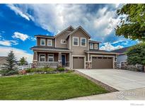 Beautiful two-story home with a well-manicured lawn and a charming front porch at 1910 High Plains Dr, Longmont, CO 80503