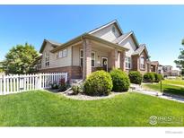 Charming home featuring a well-manicured lawn, white picket fence, and inviting front porch, perfect for enjoying the outdoors at 2196 Winding Dr, Longmont, CO 80504