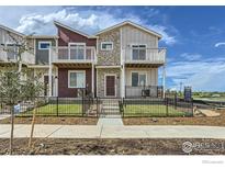 Charming townhome featuring a private balcony, fenced yard, and stone accents at 2770 Bear Springs Cir, Longmont, CO 80503