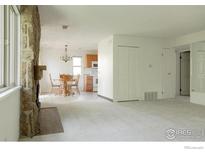Spacious living room with stone fireplace, dining area, and access to the kitchen at 3345 Chisholm Trl # 206, Boulder, CO 80301
