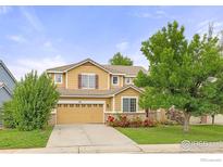 Charming two-story home with a well-manicured lawn, mature trees, and a flower bed adding curb appeal at 903 Grays Peak Dr, Superior, CO 80027
