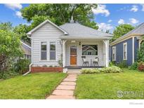 Charming home featuring a well-manicured lawn and inviting front porch seating area at 1013 La Farge Ave, Louisville, CO 80027