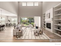 Bright living room with fireplace, built-in shelves, and sliding glass doors to outdoor living space at 1389 Lyons Ln, Erie, CO 80516