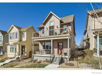 Inviting two-story home showcases a cozy front porch, complemented by a second-story balcony and neat landscaping at 1419 W 67Th Ave, Denver, CO 80221
