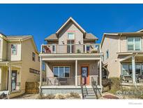 Charming two-story home featuring a welcoming front porch and second-story balcony with metal railings at 1419 W 67Th Ave, Denver, CO 80221