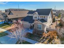 Charming two-story home features a well-manicured front yard with mature trees and neutral-toned siding at 1435 Rustic Dr, Longmont, CO 80504