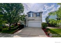 Charming two-story home boasts a well-manicured lawn and a spacious two car garage at 166 Monares Ln, Erie, CO 80516