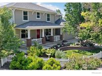 Charming two-story home featuring a landscaped yard and inviting covered front porch with brick accents at 2975 Thunder Lake Cir, Lafayette, CO 80026