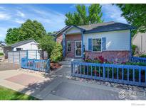 Charming home featuring brick accents, blue trim, landscaped yard, and a walkway leading to the front door at 3132 Concord Way, Longmont, CO 80503