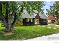 Charming home with a freshly painted exterior, black brick, new gray roof, and lush green lawn at 4545 Martin Dr, Boulder, CO 80305
