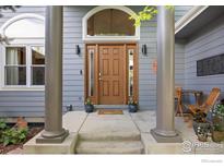 Charming front door with decorative glass and a covered entry. Columns add architectural interest at 591 Brookside Dr, Longmont, CO 80504