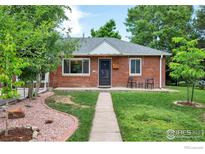 Charming red brick home featuring a well-manicured lawn and inviting front porch with mature shade trees at 6755 W 33Rd Ave, Wheat Ridge, CO 80033