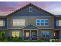 Charming townhouse featuring a covered front porch and multiple windows for natural light at 876 Winding Brook Dr, Berthoud, CO 80513