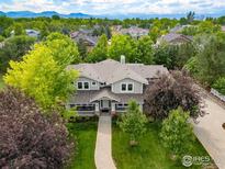 Stunning two-story home with lush landscaping, a welcoming front porch, and mountain views in the background at 1231 Hawk Ridge Rd, Lafayette, CO 80026