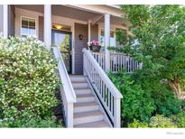 Inviting front entrance with a charming stairway, complemented by lush landscaping and a welcoming facade at 1668 Saratoga Dr, Lafayette, CO 80026