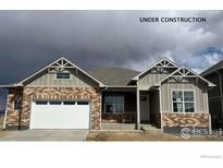New construction home displaying mixed brick and vinyl siding, with a two car garage and covered entryway at 1842 Chaffee Crest Dr, Berthoud, CO 80513
