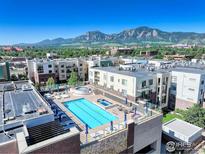 A rooftop pool deck with a pool, hot tub, and lounge chairs, all with mountain views at 3601 Arapahoe Ave # 304, Boulder, CO 80303