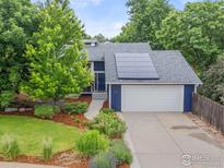 Charming home featuring solar panels, lush landscaping, and a well-maintained lawn at 400 Lois Dr, Louisville, CO 80027