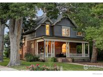 Charming two-story home featuring a covered front porch, stone accents, and beautiful mature trees at 505 Pine St, Boulder, CO 80302