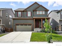 Two-story home with a well-kept lawn, a two-car garage, and an inviting front porch at 563 Green Mountain Dr, Erie, CO 80516