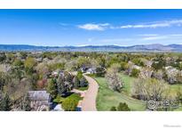 Stunning aerial view of a home nestled in a lush, green neighborhood with mountain views at 7999 Centrebridge Dr, Niwot, CO 80503