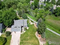 A beautiful house with a well-manicured lawn and mature trees, backing onto a trail at 7999 Centrebridge Dr, Niwot, CO 80503