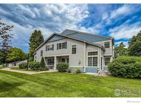 Charming gray and blue two-story home with a well-manicured lawn and lush landscaping at 1419 Red Mountain Dr # 126, Longmont, CO 80504
