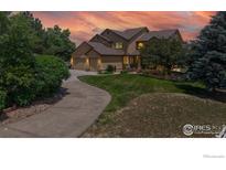 Charming home with a well-manicured lawn, mature trees, and a long driveway leading to a three-car garage at 14652 Kalamath Ct, Westminster, CO 80023