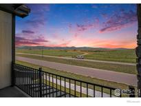 Balcony view of a rural landscape under a vibrant sunset sky at 1550 Harebell St, Berthoud, CO 80513