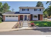 Charming two-story home with a brick and gray facade and a well-manicured front yard at 1590 Findlay Way, Boulder, CO 80305