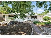 Charming one-story home featuring a welcoming front porch and beautifully landscaped yard with stone accents at 175 Iroquois Dr, Boulder, CO 80303