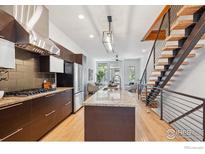 Modern kitchen featuring stainless steel appliances, dark cabinets, granite countertops, and an island at 2900 Inca St # 24, Denver, CO 80202