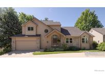 Charming two-story home with stone accents, arched entryway, and well-manicured lawn, creating a welcoming curb appeal at 322 Diamond Cir, Louisville, CO 80027