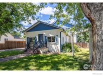 Charming home with a well-manicured lawn, mature trees, and inviting front porch at 403 W Cannon St, Lafayette, CO 80026