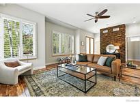 Cozy living room with a stacked stone accent wall, plush rug, and abundant natural light at 5145 Denver St, Boulder, CO 80304