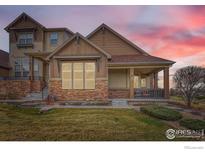 Charming home featuring a covered porch, stone accents, and beautifully landscaped front yard at 555 Gallegos Cir, Erie, CO 80516