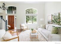 Bright living room features large windows, hardwood floors, and neutral decor at 6838 Bugle Ct, Boulder, CO 80301