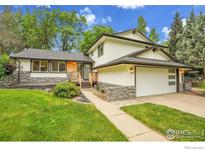 Charming home with a stone facade, well-maintained lawn, and attached two-car garage at 7146 Petursdale Ct, Boulder, CO 80301